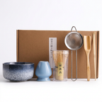 Blue speckle matcha set on a white background: bowl, whisk holder, bamboo whisk in its case, sieve, scoop and spoon, with the kraft box