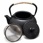 Black cast iron teapot with the lid removed and its stainless steel mesh infuser beside it