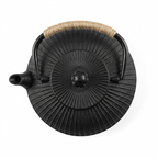 Black flat cast iron teapot seen from above, showing the ribbed lid radiating from the knob