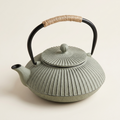 Flat cast iron teapot in grey, with a ribbed body and cord-wrapped handle