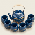 Midnight blue tea set with the gold mountains motif: teapot and six cups on a cream background