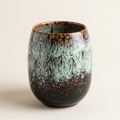 Moss green glazed tea cup from a three-quarter angle, showing the rounded egg shape and the rim