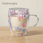 Hydrangea design: glass cup with dried blue, lilac and pink petals, filled with milk, on a light oak table
