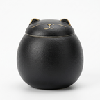 Black ceramic tea caddy with a cat-shaped lid and gold details