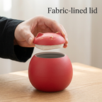 Hand lifting the red cat lid to show its fabric lining