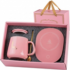 Pink mug warmer gift set in its open box: ceramic mug with gold details, lid, gold-tone spoon and pink warming plate