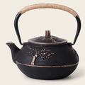 Golden tree cast iron teapot on a warm cream background