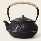 Golden tree cast iron teapot on a warm cream background